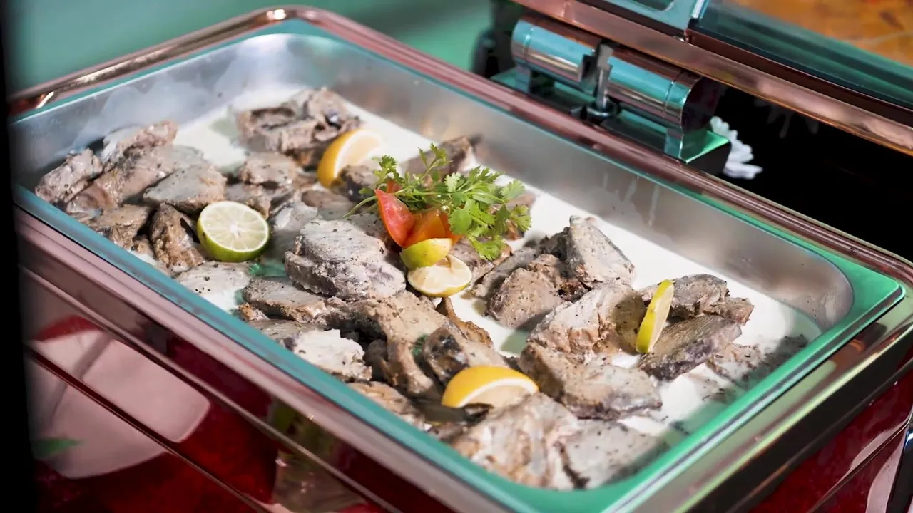 Grilled fish with lemon in a buffet chafing dish