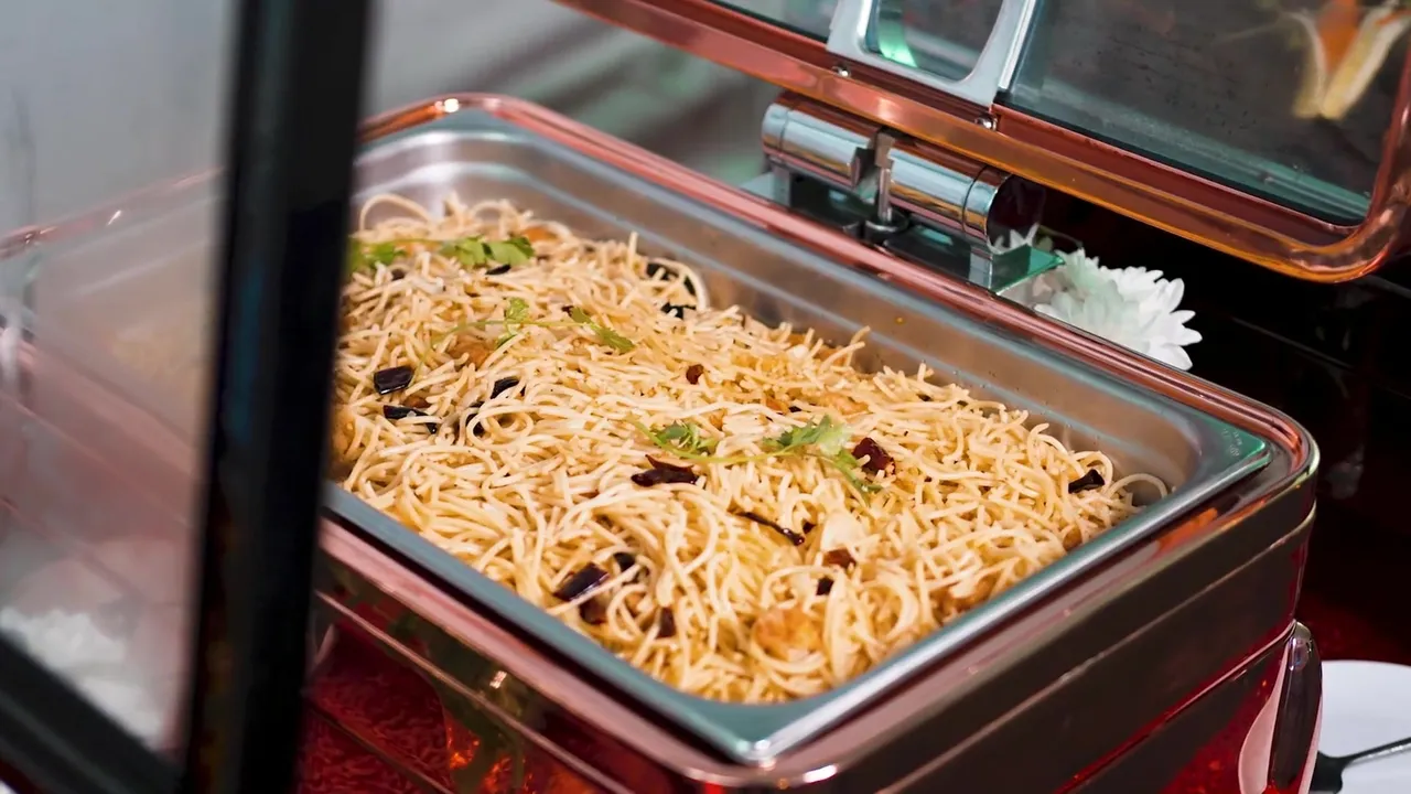 Stir-fried noodles in a copper chafing dish